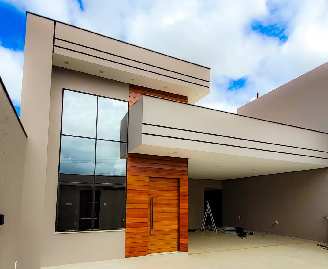 Fachada residencial com esquadrias de alumínio e porta pivotante